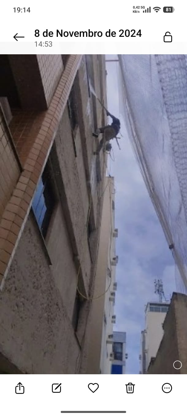 Equipe realizando pintura de fachada de prédio alto em Vitória ES